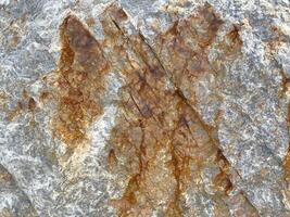 Rugged rock surface with natural brown streaks and textured patterns photo