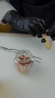 Chef adding smoked fish slice to glass jar video