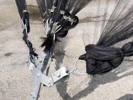 Black mesh nets and metal hooks on concrete surface detail close-up photo