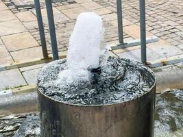Close-up of modern urban water fountain bubbling on stone pavement photo