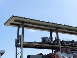 Outdoor storage rack with assorted building materials under sheltered roof photo