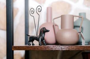 Decorative sculptures and vases on a wooden shelf in modern home interior photo