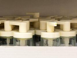 Organized row of white soap dispensers with pump nozzles in retail shelf display photo