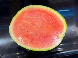 Fresh cut watermelon with juicy red flesh and green rind on display photo