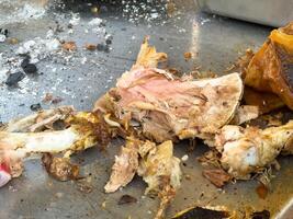 Cooked meat bones on metallic surface with charred remnants photo