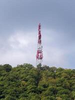 Directional antenna array on a red and white communication tower against sky photo