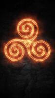 Fiery Celtic triskelion triple spiral symbol flaming on a dark stone background. Mystical elemental energy concept. Vertical animation. video