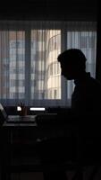 vertical Programmer working from home in dark room with laptop video