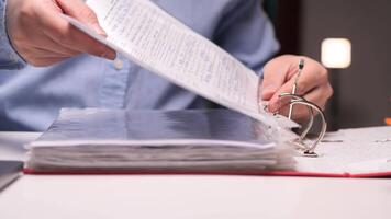Office worker filing documents in a ring binder at night video
