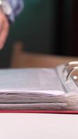 vertical Office worker browsing through documents in a binder video