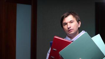 Office worker struggling with stack of binders and files video