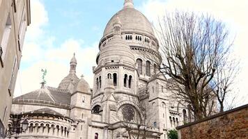 Rear view of Sacre Coeur Basilica with trees and stone wall in Paris video