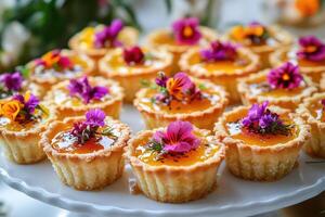 A white plate topped with mini cupcakes with flowers photo