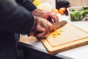 Healthy eating preparation in restaurant kitchen, chef slicing vegetables with focus and precision. photo