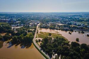 Aerial view of flooded street, railway tracks and buildings in a suburban area. Industrial zone with floodwater after heavy rain. Concept of natural disaster, climate impact and emergency photo
