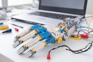 DIY robotic hand project with wires on white desk in home lab photo
