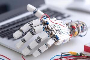 Robotic prosthetic hand prototype with wires and components on desk photo