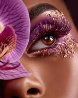 Model showing creative purple and gold makeup with orchid photo