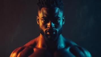 A muscular man posing dramatically with colorful lighting at dusk photo