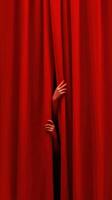 Mysterious hands emerging from red curtains photo