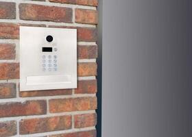 Metal Keypad Intercom on Corner Brick Wall photo