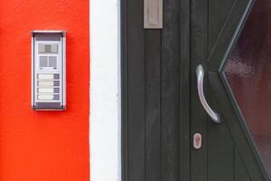 Door intercom on red wall in Burano Italy photo