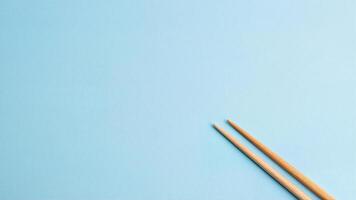 Bamboo Chopsticks Isolated on Blueneutral solid Background photo