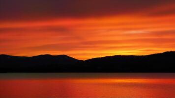 Vivid Sunset Over Calm Mountain Lake photo