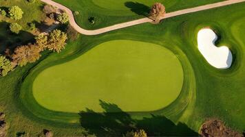 Aerial view of green grass and trees on a golf fields and sandy areas. green golf course in summer. Top view. photo