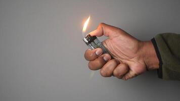 Hand holding a lighter with a neutral background for demonstration video