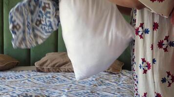 Making a bed with fresh linens and throwing pillows video