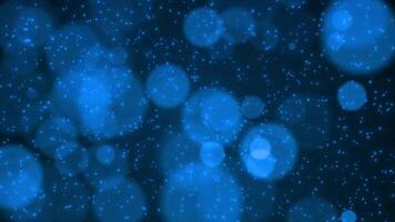 Background of blue particles from which glow emanates. Mesmerizing bokeh effect. Colorful abstract background 4K, seamless loop. video
