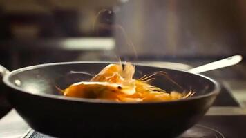 a side view closeup shot of a delicious shrimp cooks in a frying pan with toss video