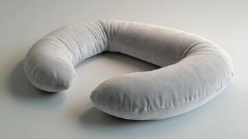 A grey neck pillow on a white surface photo