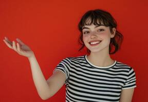 Portrait of a Smiling Young Woman with Bangs Wearing a Striped Shirt Against a Red Background photo
