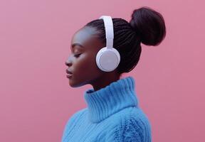 Serene Young Woman Listening to Music with White Headphones Against a Pink Background photo
