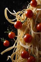 A pile of spaghetti with tomatoes on top photo