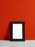 A black square frame on a red wall photo