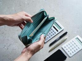 A person holding a wallet with a calculator and other items photo
