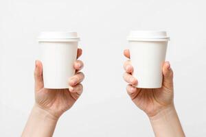 Two hands holding two white paper coffee cups photo
