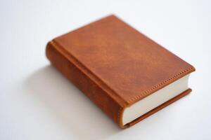An old brown book on a white surface photo