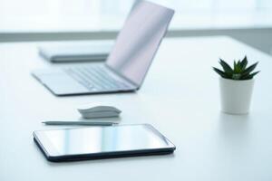 Tablet and laptop on white table photo