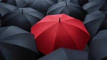 A red umbrella stands out among black umbrellas photo