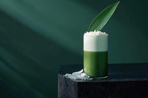 Pandan coconut milk tea served in a tall glass on a striking black quartz countertop with stylish garnishments photo