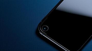 A black iphone sitting on a blue surface photo