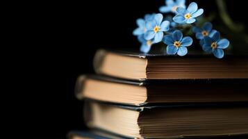 A stack of books with blue flowers on top photo
