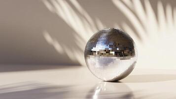 Silver disco ball reflects light on clean surface photo