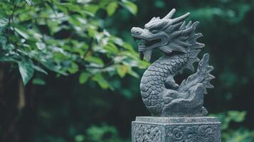 A stone statue of a dragon in front of a green tree photo