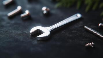 A wrenet and screws on a black surface photo