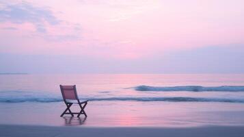 A chair sits on the beach at sunset photo